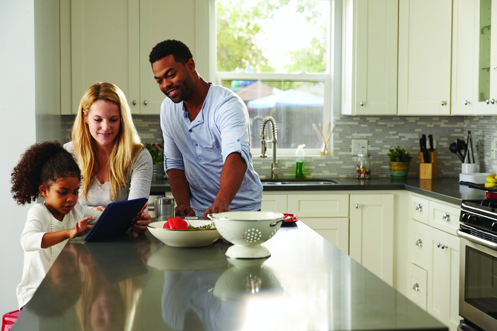 family looking at tablet in the kitchen