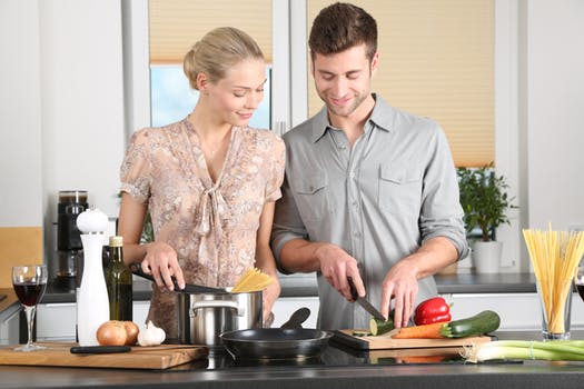 couple chopping vegetables and cooking
