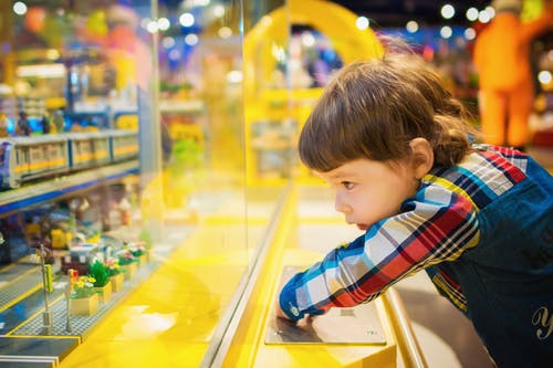 child looking at toys behind the glass