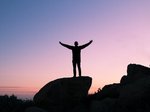 open arms on top of a rock