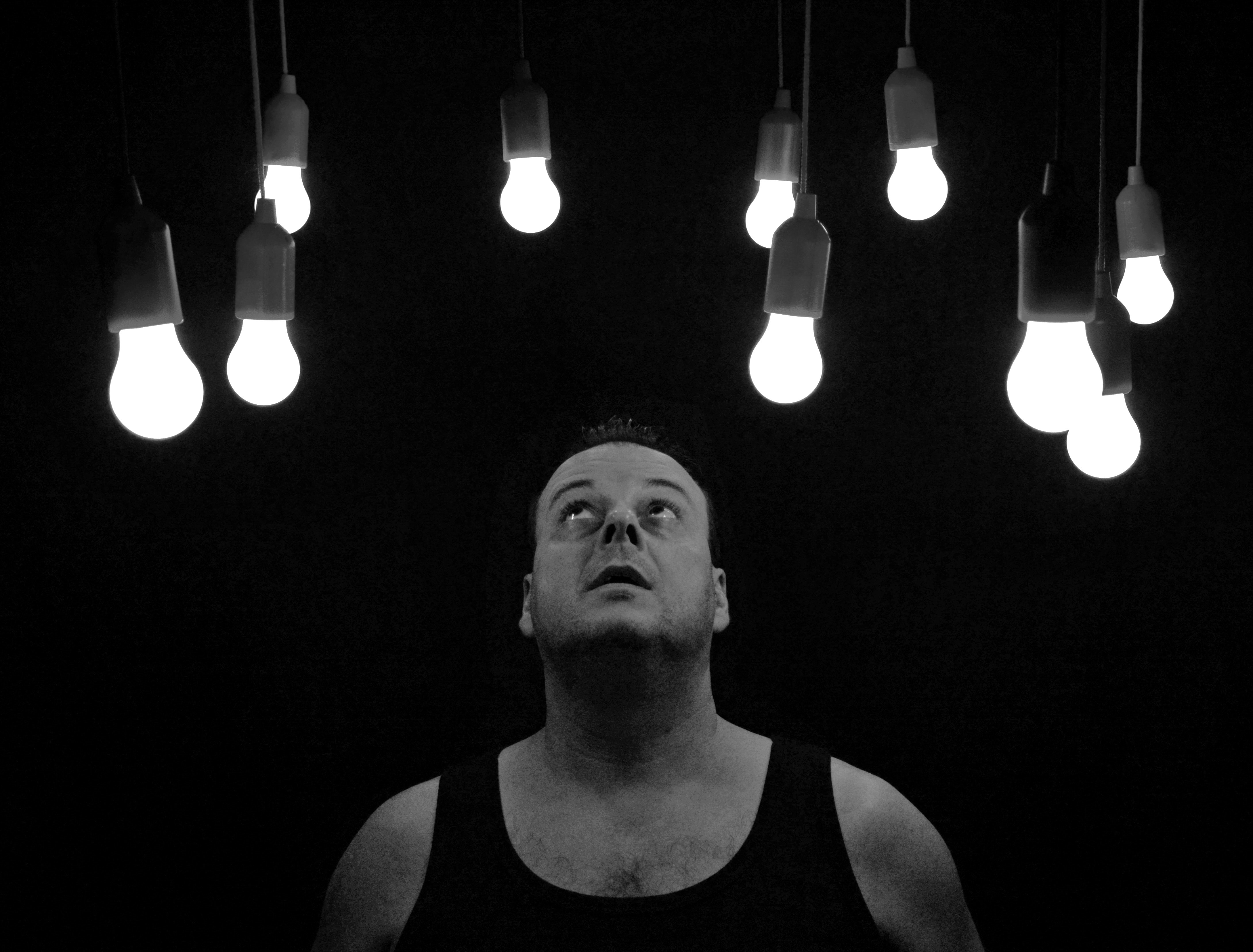 man looking at light bulbs